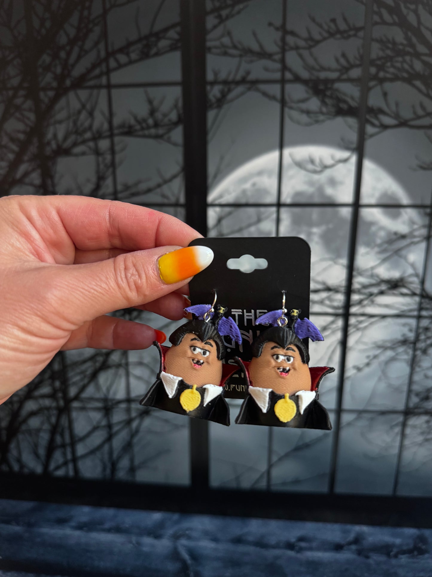 Handmade vampire nugget buddy dangle earrings with purple hair, a black high collar cape and a gold medallion