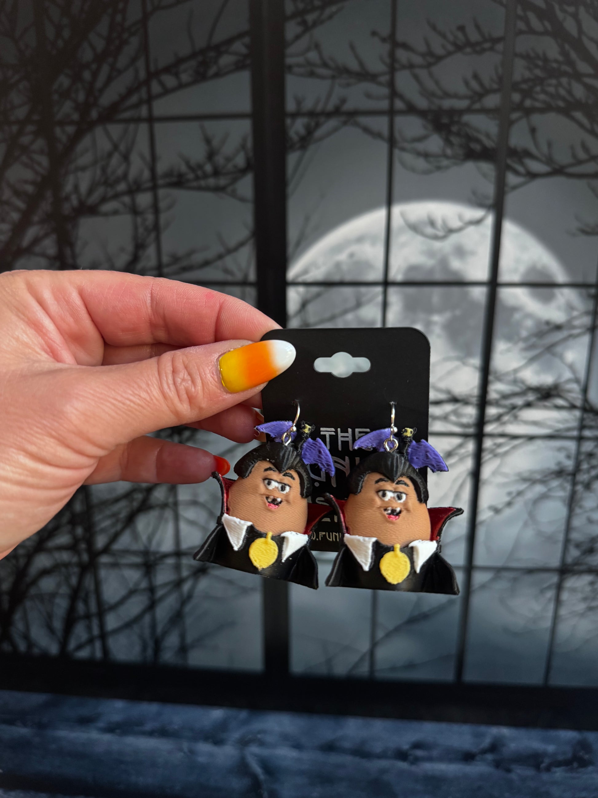 Handmade vampire nugget buddy dangle earrings with purple hair, a black high collar cape and a gold medallion